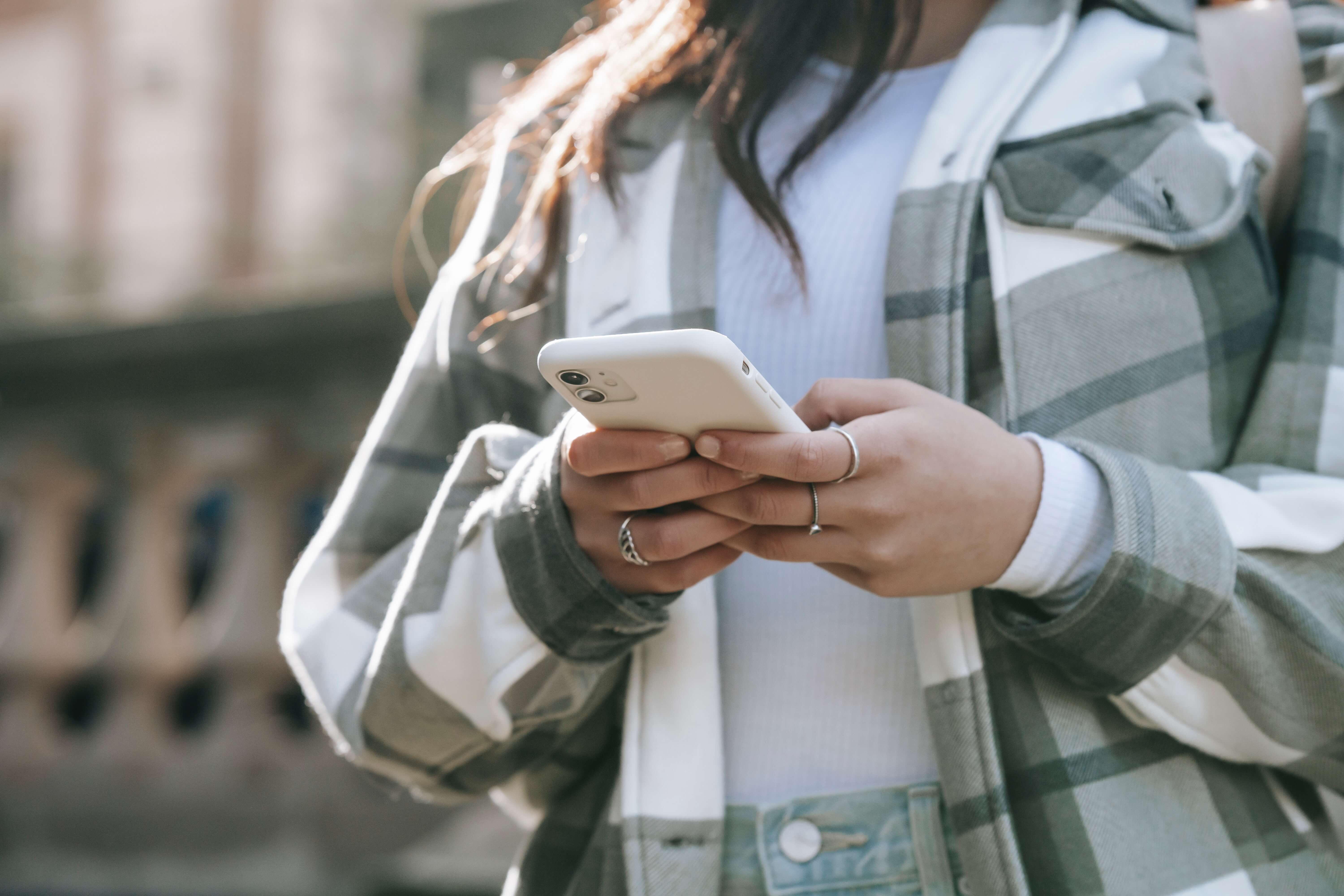woman in a flannel holding her phone